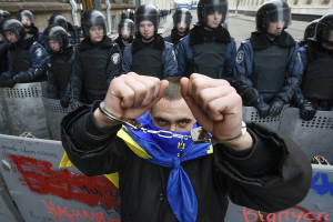 Un opositor ucraniano posa frente a la prensa extranjera. Detrás, la policía de Kiev_EFE