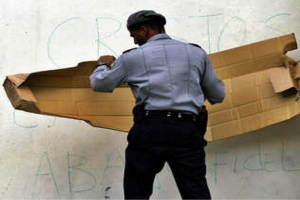 Policía cubano tapa carteles antigubernamentales_foto tomada de internet