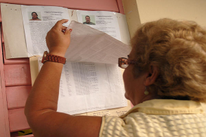 Mujer cubana lee listas de canditados a delegados al Poder Popular_Internet