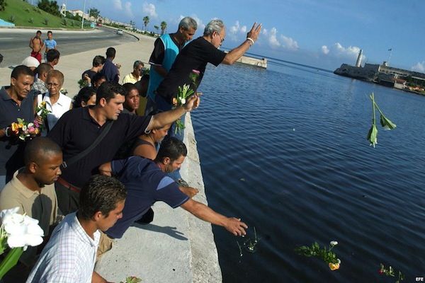 cubanos lanzan flores al mar en el malecon