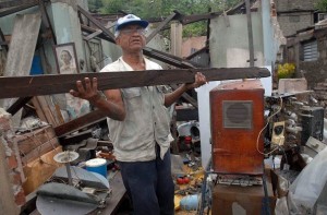 Un hombre recoge escombros de entre sus pertenencias, en Santiago de Cuba, por donde pasó el huracán Sandy en octubre de 2012_foto EFE