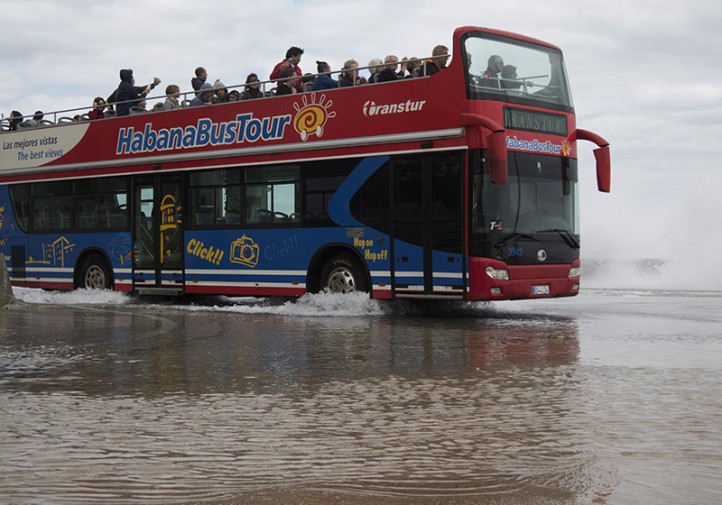 Bus turístico transita sobre calle inundada