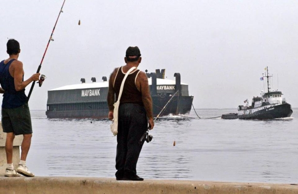 Pescadores cubanos observan a un buque mercante estadounidense entrar en el puerto de La Habana (Foto: Adalberto Roque/AFP/Getty)