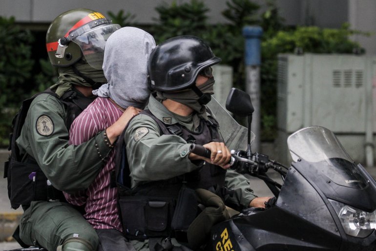 La Guardia Nacional Bolivariana (GNB) se lleva a un manifestante opositor durante una protesta