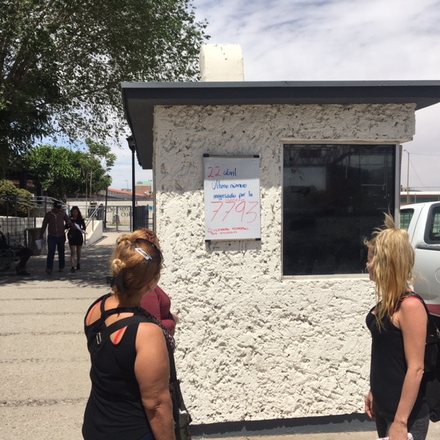 Cubanos frente a la lista de migrantes en cola para cruzar la frontera