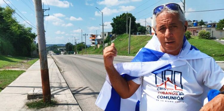 El pastor y periodista cubano Alejandro Hernández Cepero con la bandera de Israel sobre su espalda