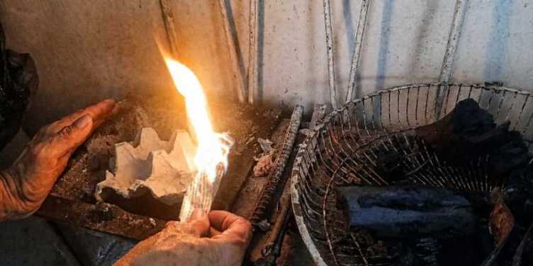 La madre de la autora intenta prender un fogón artesanal durante el apagón