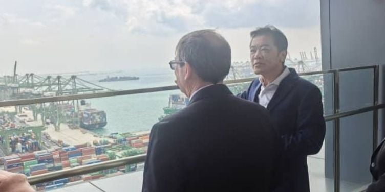 El canciller del régimen cubano, Bruno Rodríguez Parrilla (de espaldas) durante una visita a la sede de PSA International, en Singapur, en febrero de 2025